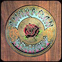 A woodgrain panel with a circle in the middle—inscribed is a rose surrounded by the words "American Beauty".