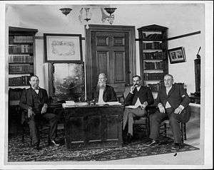 four men and desk
