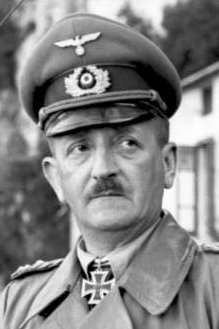 A man wearing a military uniform with an Iron Cross displayed at the front of his uniform collar.