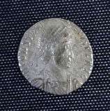 A smaller silver coin in the centre a head - still a fairly round coin but the inscription is not intact and there is no space between it and the rim