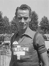 A cyclist wearing a jersey with a cross on it.
