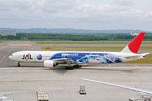 A Japan Airlines Boeing 777–300 painted in special Oneworld livery, taxiing at New Chitose Airport