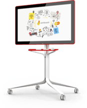 The Google Jamboard, which a=is accented red in the back and shelf containing the styluses and eraser, is facing forward at a titled angle on it's vertical stand.