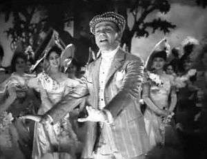 Cagney on stage and in costume, singing and dancing while the cast watches