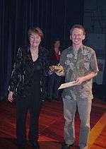 Jan Wright presenting a trophy to Axel Wilke, Axel holding a certificate