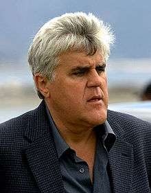 Jay Leno in a sports jacket, looking to his left