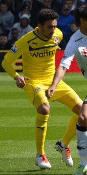 Jem Karacan, wearing Reading's 2012–13 away kit, contests with Bryan Ruiz for the ball