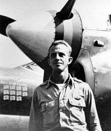 Then Maj. John Loisel standing in front of his P-38 Lightning fighter, showing Japanese flags painted on to indicate 11 kills