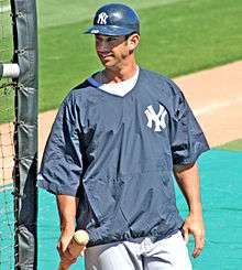 Jorge Posada stands next to the batting cage wearing a New York Yankees windbreaker