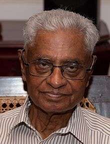 An image of a grey-haired Indian man with glasses