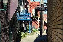 KFAI sign up and the rear of old buildings with brightly colored woodwork