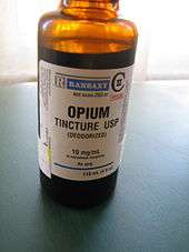 Orange transparent bottle labelled "opium tincture USP (deodorized)." There is a warning label declaring the product to be poisonous.