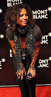 Linda Perry standing while putting her hands on her keens