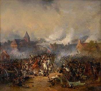Painting of French and Prussian soldiers firing at each other while only a few meters apart with the Plancenoit church in the background