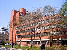 Manchester Business School: large, red-brick building with trees in front