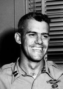 A black-and-white photo of Humbert Versace wearing his military uniform . Two military badges are clearly visible on the left breast pocket.