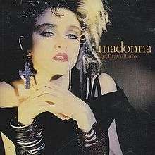 Madonna wearing crucifix earrings and multiple plastic wrist bracelets around right wrist