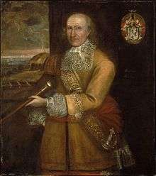 Painting of a balding man with grey hair.  The man is wearing a highly decorated coat, and he is holding a staff of sorts.