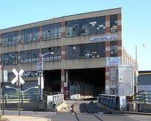 The Bushwick Branch, a single-track railroad, crosses Flushing Avenue on a bridge and then goes into the Maspeth Industrial Center, an industrial building