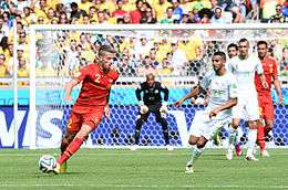 Belgian defender maneuvering around the Algerian goal