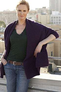 Melissa Rosenberg standing against a city background.