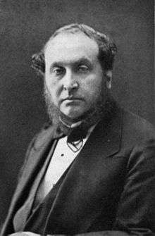 photograph  of middle-aged man with bushy sideboards facing spectator, in jacket, waistcoat and bowtie