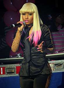 A woman with blonde hair and pink tips singing
