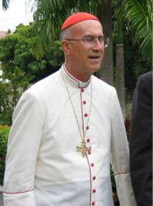 Tarcisio Cardinal Bertone in dress for hot tropical countries (white cassock with scarlet piping and buttons).
