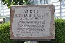 A stone monument with "Yukon Czech Hall: Bohemian Hall" and a description of the hall inscribed on it