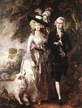 "A man and a woman walking next to a wood with their white dog. The woman is dressed in a white 18th century gown and a black hat, and the man is dressed in a black suit with white stockings."