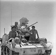 Three soldiers sitting on a tank