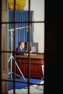  A view of President Nixon at the Wilson Desk as seen though a window into the Oval Office.