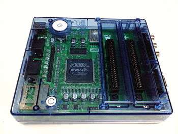 A circuit board and microprocessor in a transluscent blue case, with cartridge ports on the right hand side.