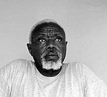 black-and-white portrait of an elderly African man with white hair and beard