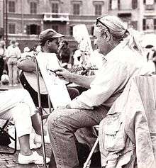 A photograph depicting Italian xpressionist painter Paolo Salvati while painting in Piazza Navona