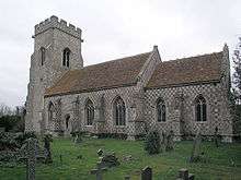 A stone church with a chequerboard appearance; on the left is a battlemented tower, the nave has three windows and the chancel, which is lower, has two windows