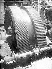 A pair of large helical gears in a ship's engine room, mounted herringbone-fashion.