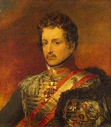 Painting shows a brown-haired man with a moustache wearing a red hussar uniform.