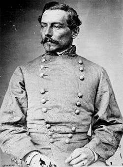Head and torso photograph of a high ranking Confederate army officer. He has short dark hair, a mustache, and small goatee