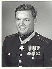 A black and white image showing the head and torso if Pittman wearing his Marine Corps dress uniform with medals. His Medal of Honor is visible around his neck.