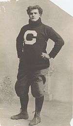 Large young man in a turtleneck and football pants, with hands on hips