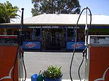 Photo of shop front behind two fuel pumps
