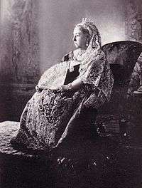Seated Victoria in embroidered and lace dress