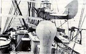 Rear view of biplane on floats aboard a ship
