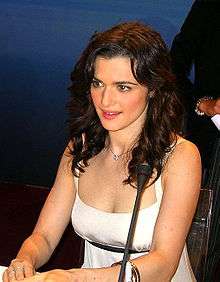 Weisz seated in front of a microphone