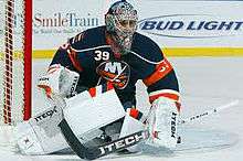 Rick DiPietro in front of his goalie net, blocking an oncoming puck.