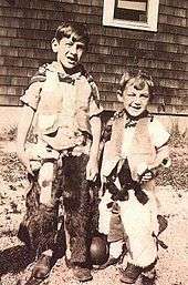 A black and white photograph of two young children aged approximately six and three dressed as cowboys