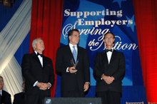Photograph of Romney flanked by two other men at a formal awards occasion