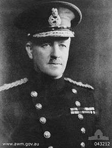 Head and shoulders of man in uniform with high collar and peaked cap.