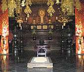 Elaborately decorated room, symmetrical, with a gold colored statue on an altar